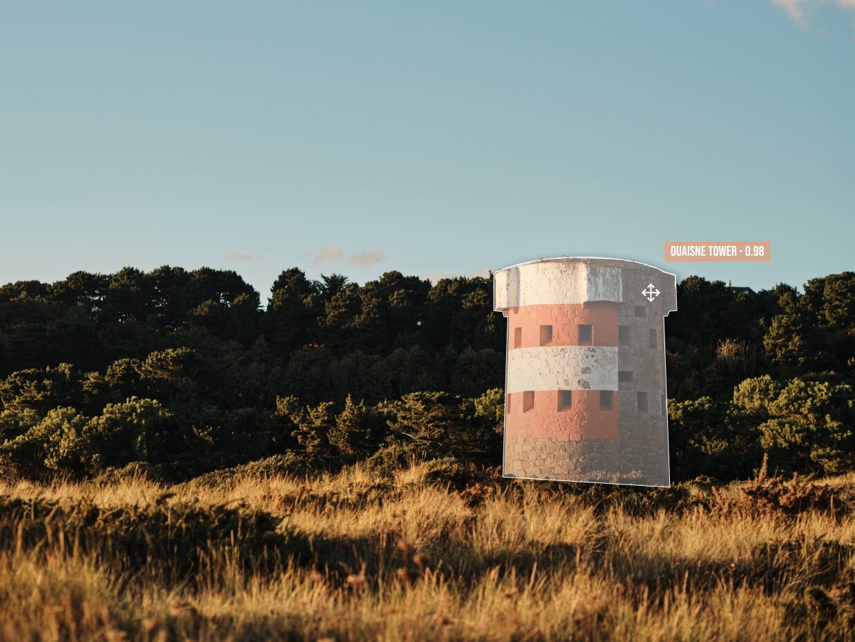 A round red and white striped Jersey coastal tower among trees, outlined by a detection overlay with a label reading Quaisne Tower 0.98